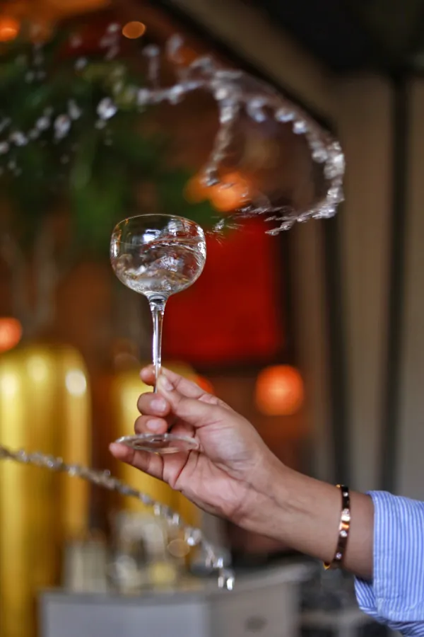 A cocktail raised in a warmly lit bar