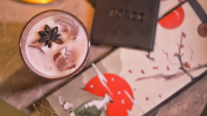 A pink cocktail with star anise garnish